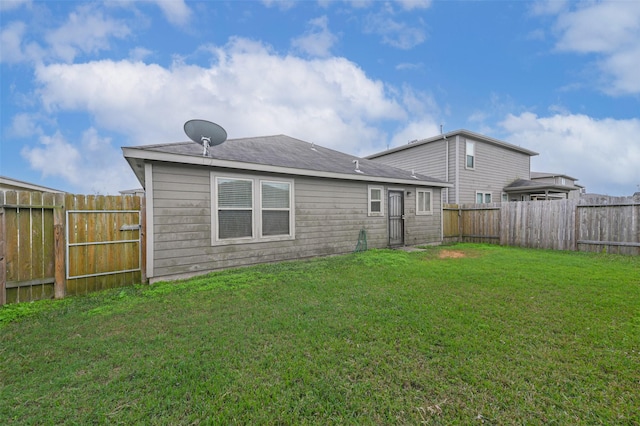 back of house featuring a fenced backyard and a yard