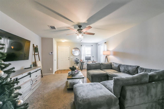 living area with visible vents, baseboards, light colored carpet, and ceiling fan