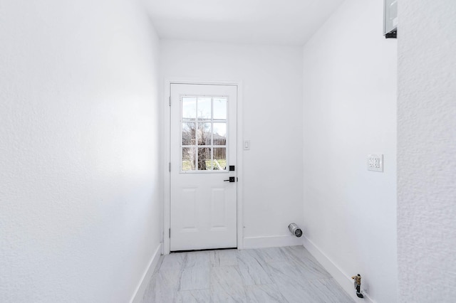 entryway with baseboards and marble finish floor