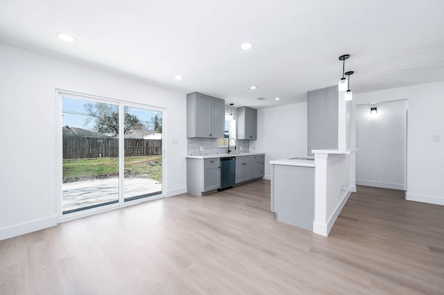 kitchen with dishwasher, light countertops, tasteful backsplash, and gray cabinets