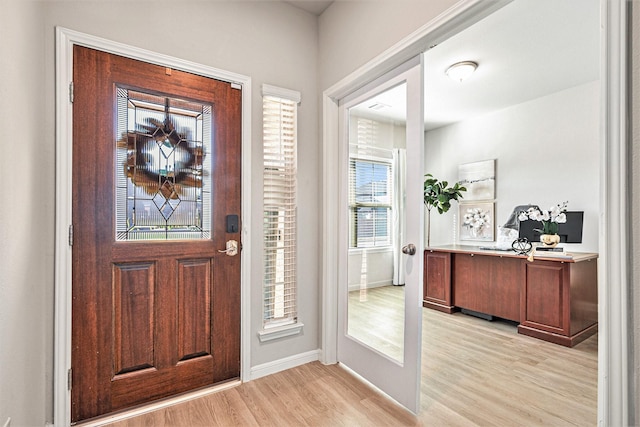 foyer entrance featuring baseboards and light wood-style flooring