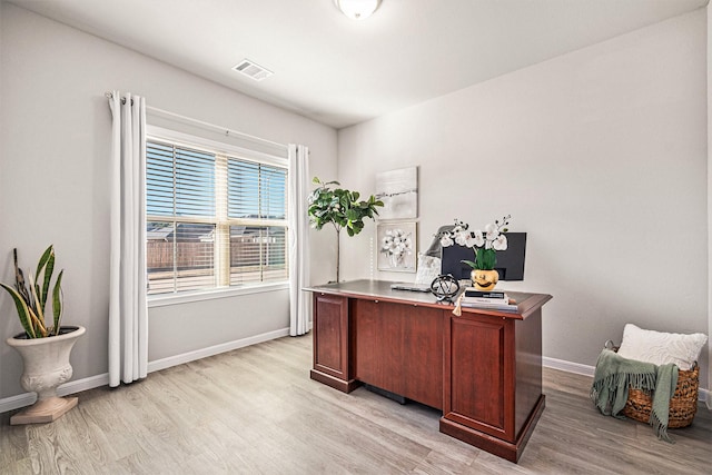 home office with visible vents, light wood-type flooring, and baseboards