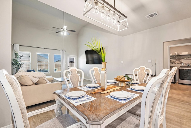 dining area with a ceiling fan, washer / dryer, light wood-style floors, and visible vents