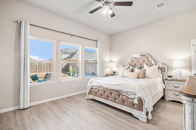 bedroom with visible vents, a ceiling fan, baseboards, and wood finished floors