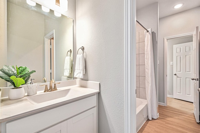 full bath with vanity, wood finished floors, baseboards, recessed lighting, and shower / tub combo with curtain