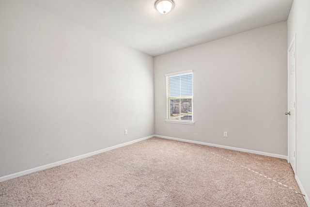 carpeted spare room featuring baseboards