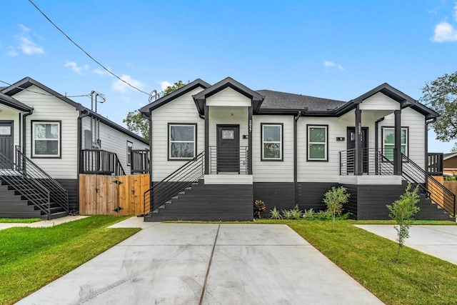 view of front of property featuring a gate, roof with shingles, a front yard, and fence