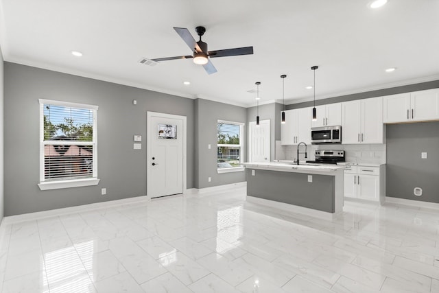 kitchen featuring marble finish floor, ornamental molding, appliances with stainless steel finishes, light countertops, and baseboards