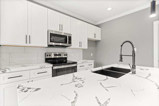 kitchen with a sink, backsplash, stainless steel appliances, white cabinets, and crown molding