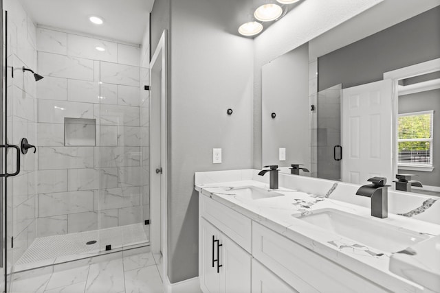 full bathroom featuring a sink, marble finish floor, a stall shower, and double vanity