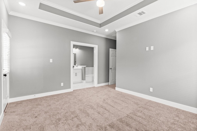 unfurnished bedroom featuring a tray ceiling, carpet flooring, crown molding, and baseboards