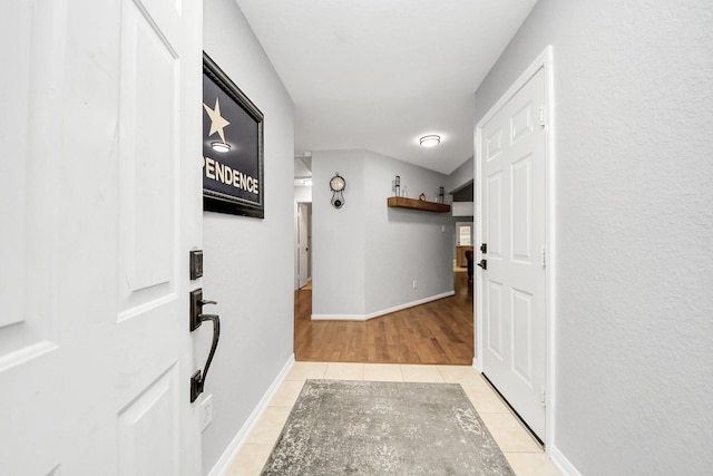 foyer entrance with light tile patterned flooring and baseboards