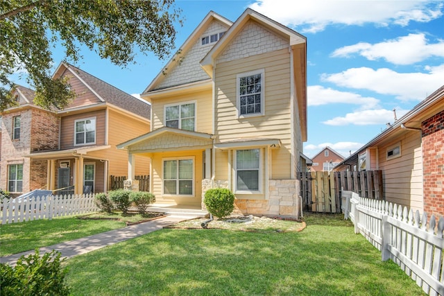 view of front of property with stone siding, fence private yard, and a front yard