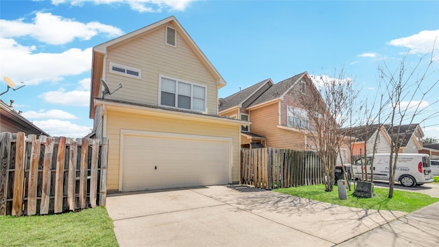 traditional home featuring fence, a garage, and driveway