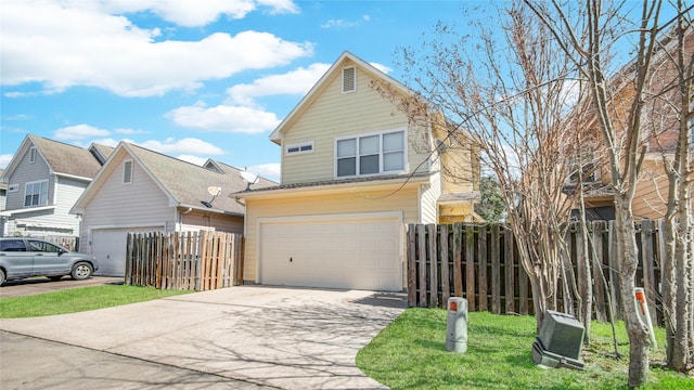 traditional-style home featuring fence, a garage, and driveway