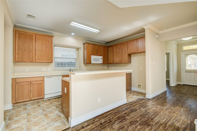 kitchen featuring white appliances, baseboards, ornamental molding, light countertops, and a center island