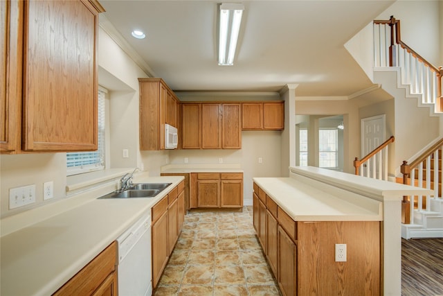 kitchen featuring white appliances, ornamental molding, light countertops, and a sink