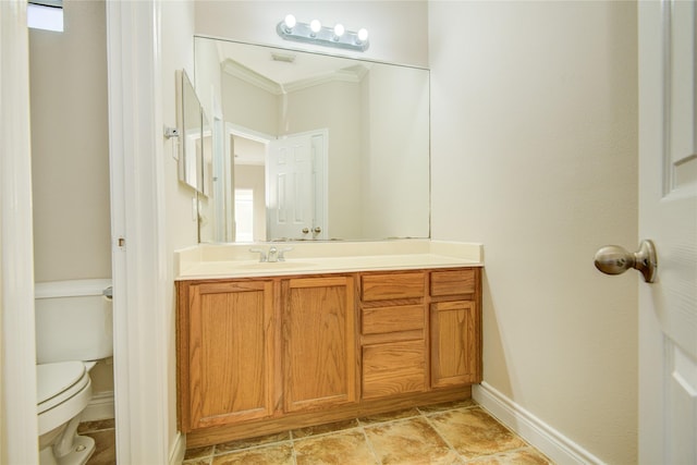 bathroom featuring baseboards, toilet, and vanity