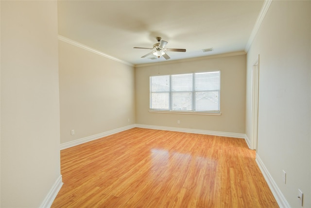 spare room with baseboards, ornamental molding, and light wood finished floors