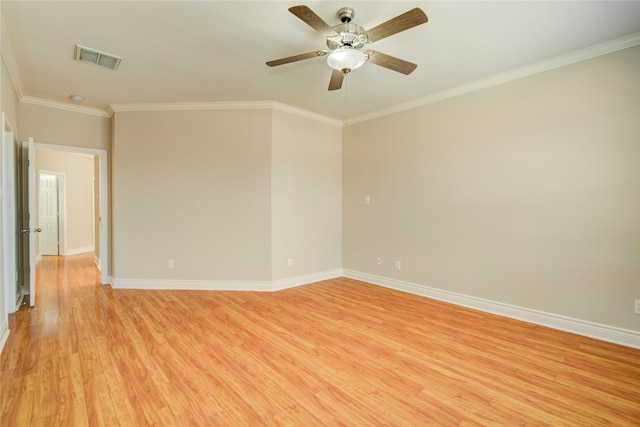 unfurnished room with visible vents, light wood-style flooring, baseboards, and ornamental molding