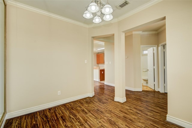 empty room featuring visible vents, dark wood-type flooring, crown molding, baseboards, and a chandelier