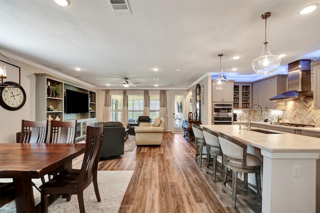 dining room with recessed lighting, visible vents, light wood-style flooring, and ornamental molding