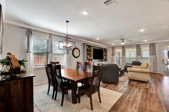 dining room with visible vents, light wood-type flooring, baseboards, and ornamental molding