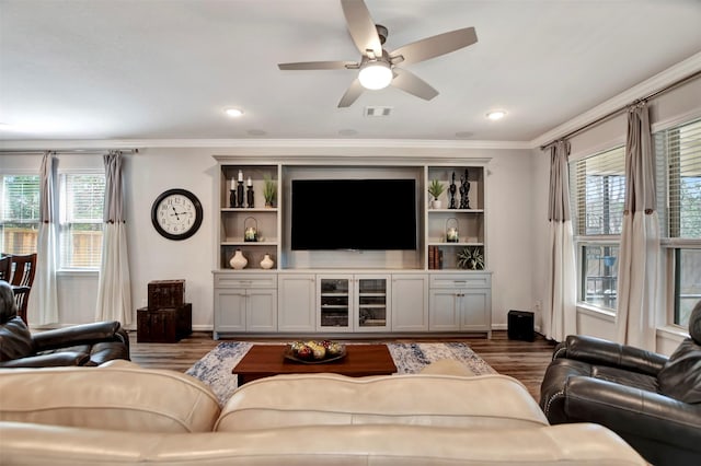 living room featuring visible vents, dark wood-type flooring, baseboards, and ornamental molding