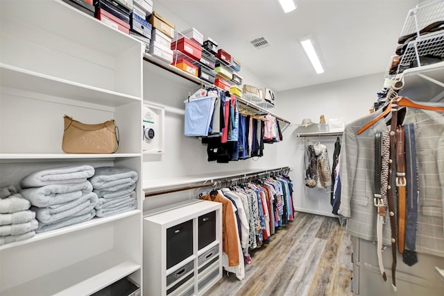 walk in closet with visible vents and wood finished floors