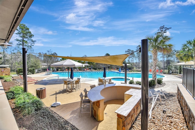 community pool featuring a patio and fence