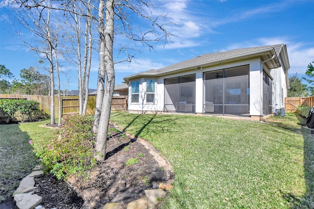 rear view of property with a yard, a fenced backyard, and a sunroom