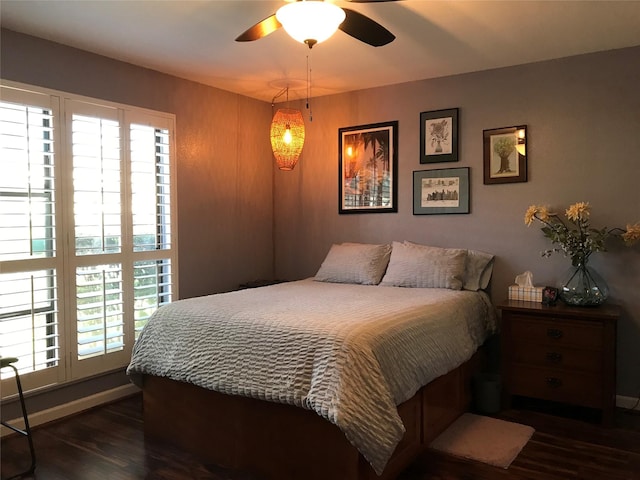 bedroom with baseboards, dark wood finished floors, and a ceiling fan