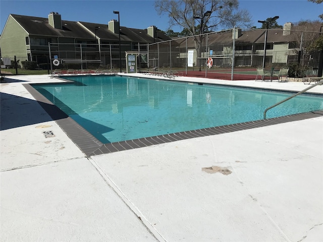 community pool with fence and a residential view