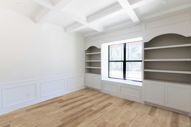 unfurnished room with beamed ceiling, built in shelves, coffered ceiling, and light wood finished floors