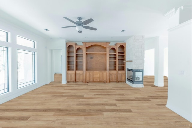 unfurnished living room featuring light wood-style flooring, a fireplace, and ornamental molding