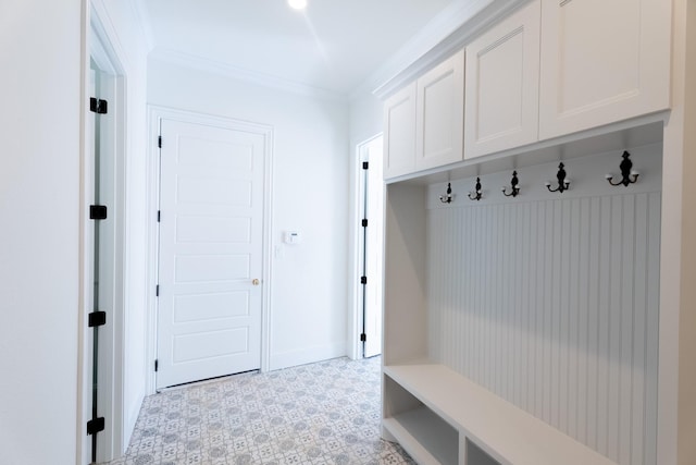 mudroom with light floors, crown molding, and baseboards