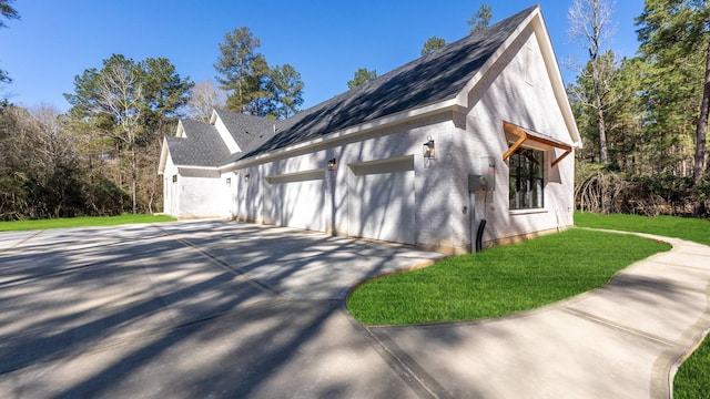 view of property exterior featuring an attached garage, driveway, and a yard