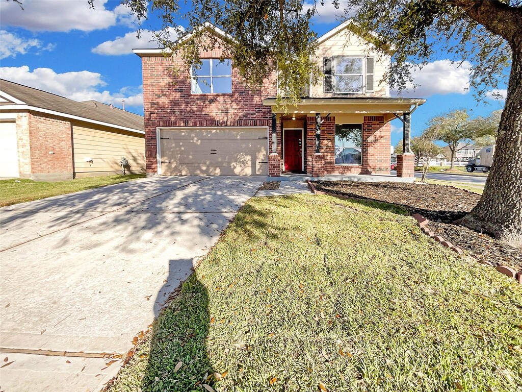 739 Remington Walk Ct, Houston, TX 77073 - traditional-style home featuring a front lawn, a porch, concrete driveway, an attached garage, and brick siding