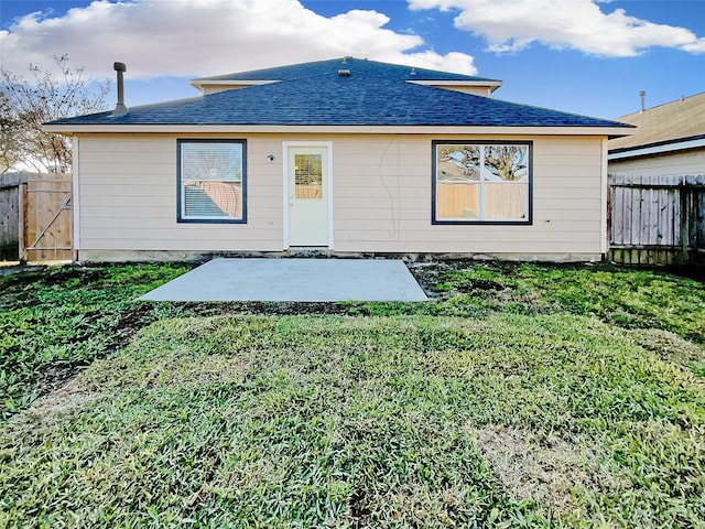 rear view of property with a patio, a lawn, and fence