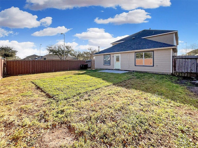 back of house featuring a yard, a patio, and a fenced backyard