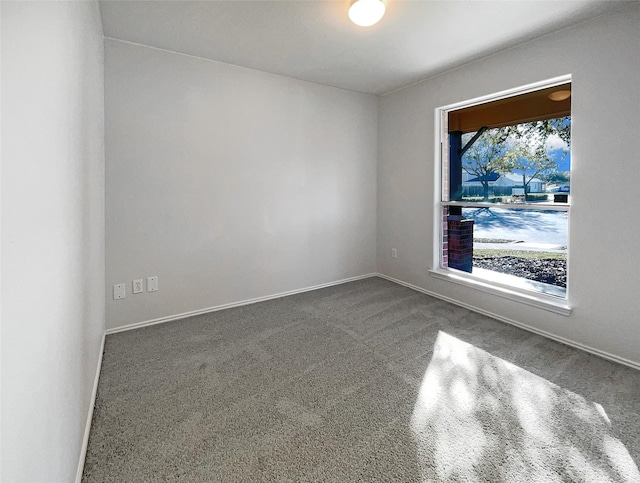 carpeted empty room featuring baseboards