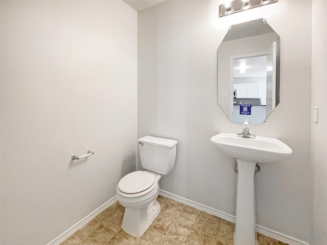 bathroom featuring baseboards and toilet