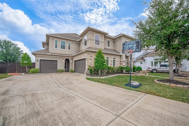 view of front facade with stucco siding, driveway, fence, a front yard, and a garage