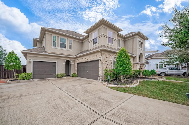 view of front of property with fence, a front yard, stucco siding, driveway, and an attached garage