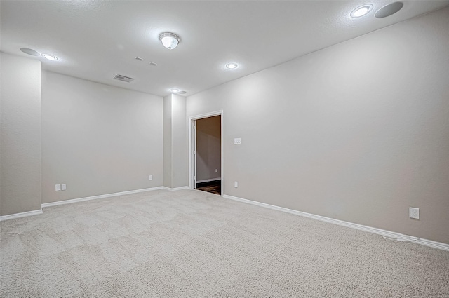 carpeted spare room with recessed lighting, baseboards, and visible vents