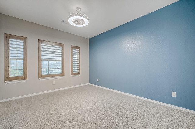 carpeted spare room with baseboards and visible vents