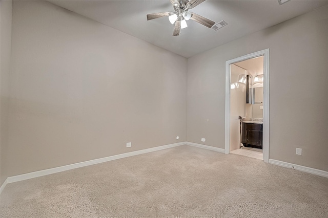 unfurnished room featuring visible vents, light colored carpet, baseboards, and ceiling fan