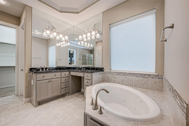 bathroom featuring a walk in closet, ornamental molding, a sink, a tub with jets, and a shower stall