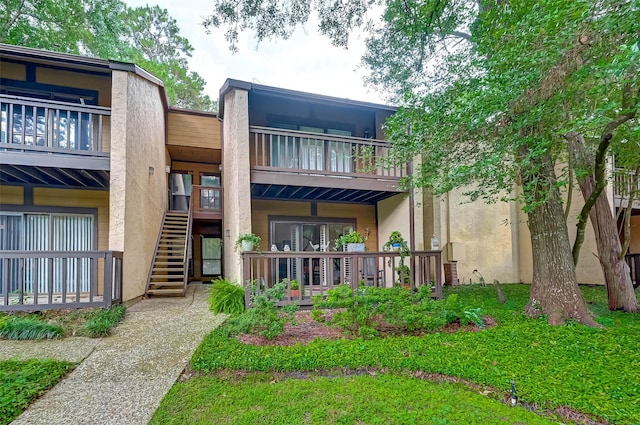 rear view of house featuring a balcony and stairway