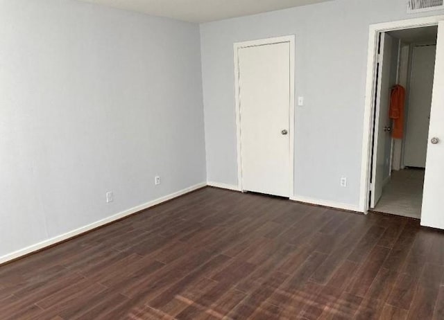 unfurnished bedroom featuring visible vents, baseboards, and dark wood-style floors